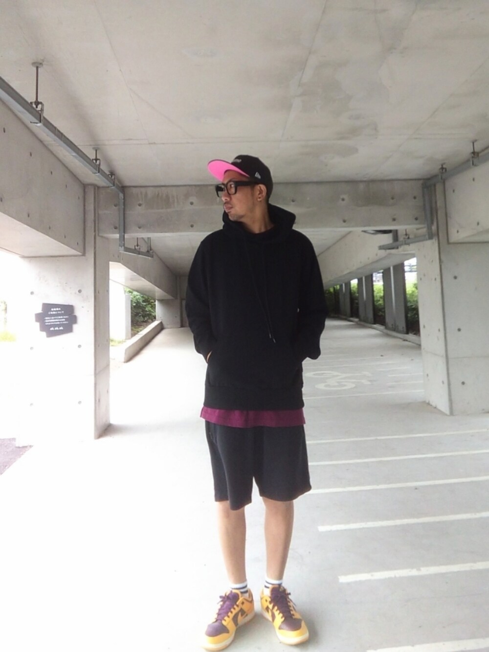 ブラック系のパーカー、ブラック系のその他パンツ、イエロー系のスニーカーを着用したメンズの秋コーディネートの3枚目の写真