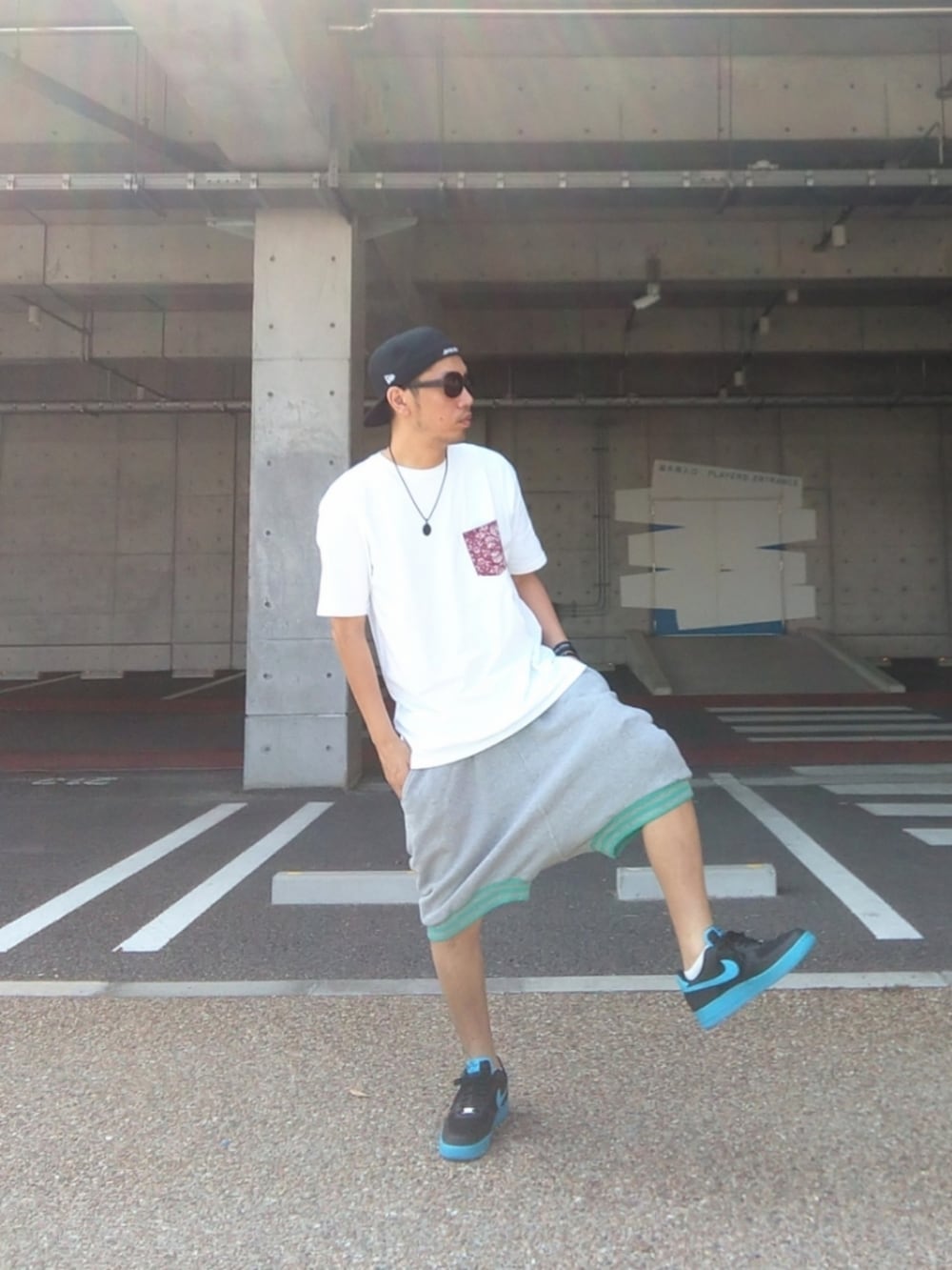 ホワイト系のTシャツ/カットソー、グレー系のその他パンツ、ブルー系のスニーカーを着用したメンズの夏コーディネートの3枚目の写真