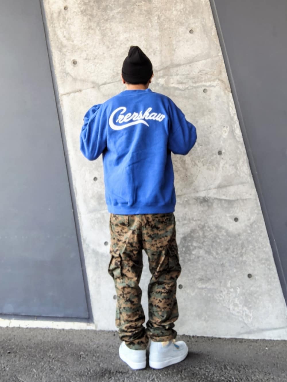 ブルー系のスウェット、グリーン系のカーゴパンツ、グレー系のスニーカーを着用したメンズの春コーディネートの2枚目の写真