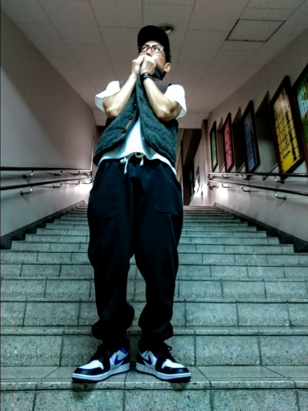 グレー系のベスト、ホワイト系のTシャツ/カットソー、ブラック系のスウェットパンツを着用したメンズの夏コーディネートの3枚目の写真