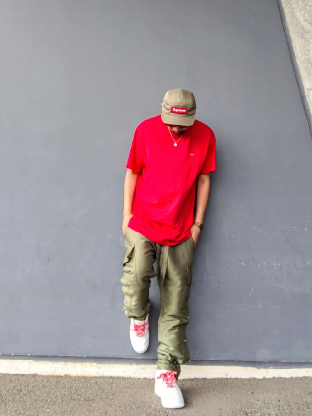 レッド系のTシャツ/カットソー、グリーン系のその他パンツ、ホワイト系のスニーカーを着用したメンズの夏コーディネートの4枚目の写真