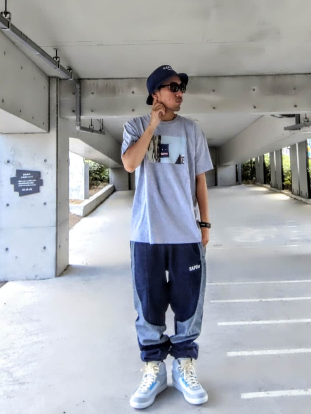 グレー系のTシャツ/カットソー、ブルー系のデニムパンツ、グレー系のスニーカーを着用したメンズの夏コーディネートの2枚目の写真