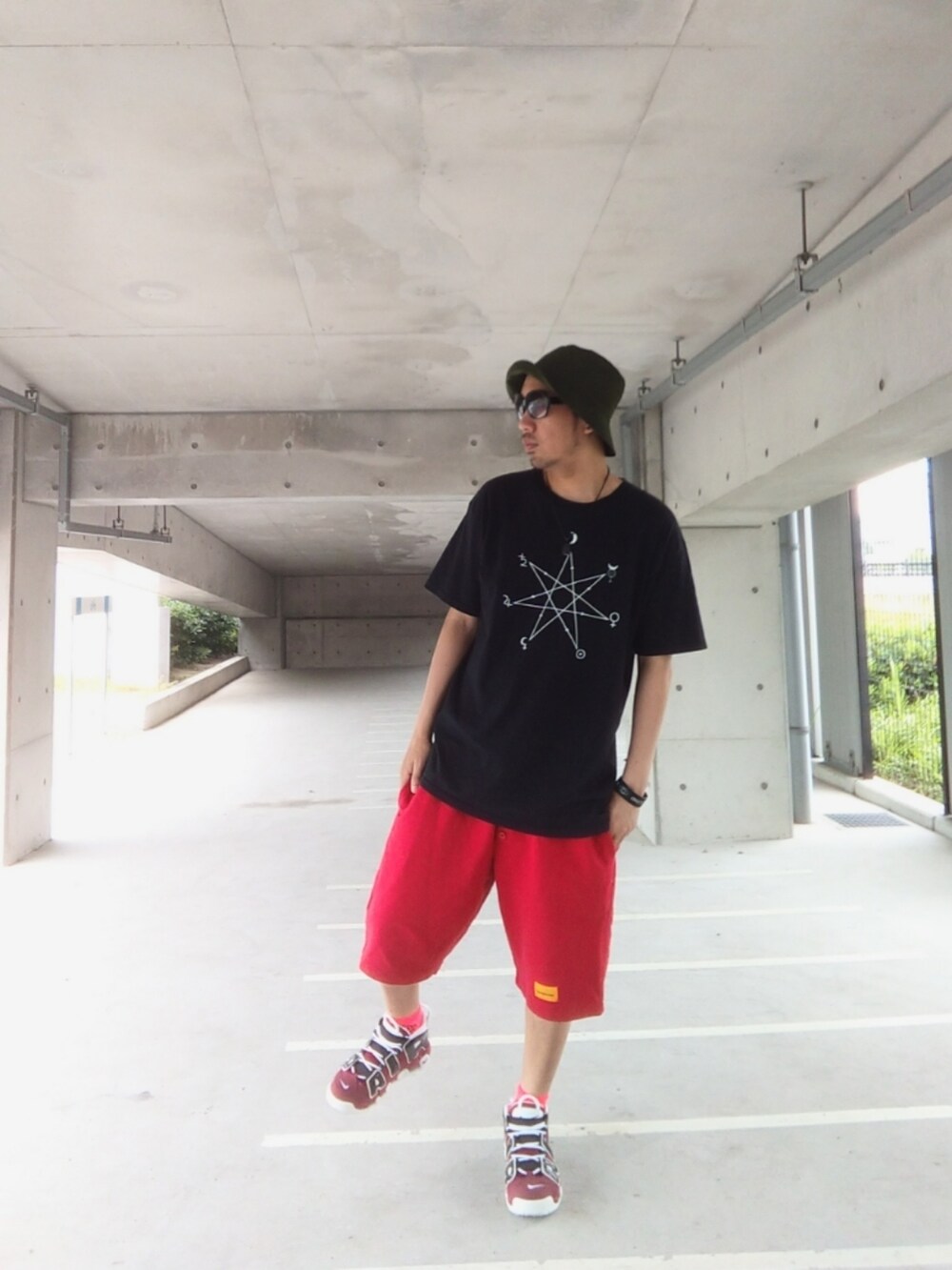 ブラック系のTシャツ/カットソー、レッド系のその他パンツ、レッド系のスニーカーを着用したメンズの夏コーディネートの3枚目の写真