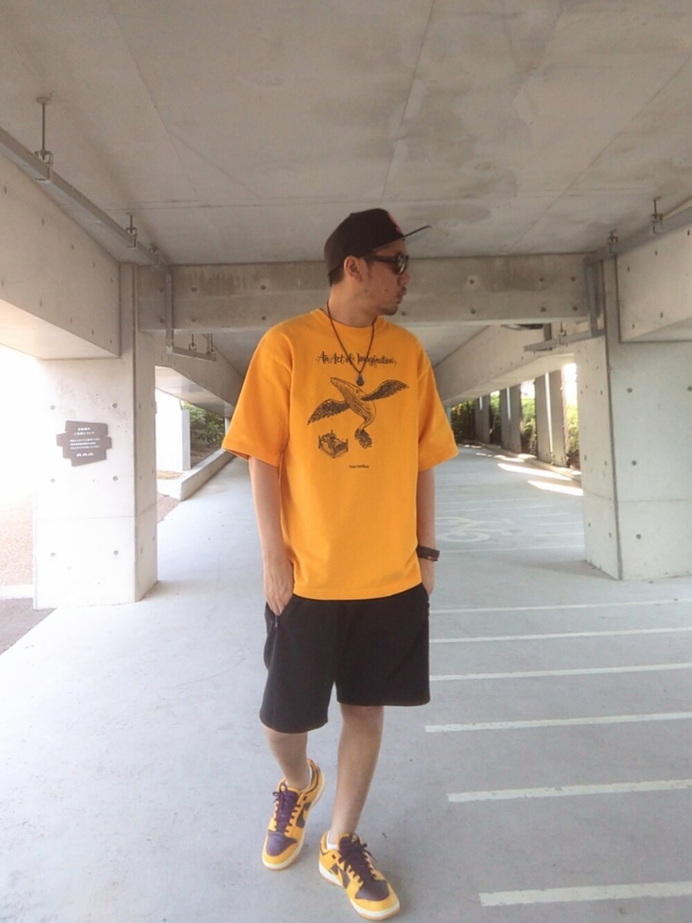 イエロー系のTシャツ/カットソー、ブラック系のその他パンツ、イエロー系のスニーカーを着用したメンズの秋コーディネートの3枚目の写真