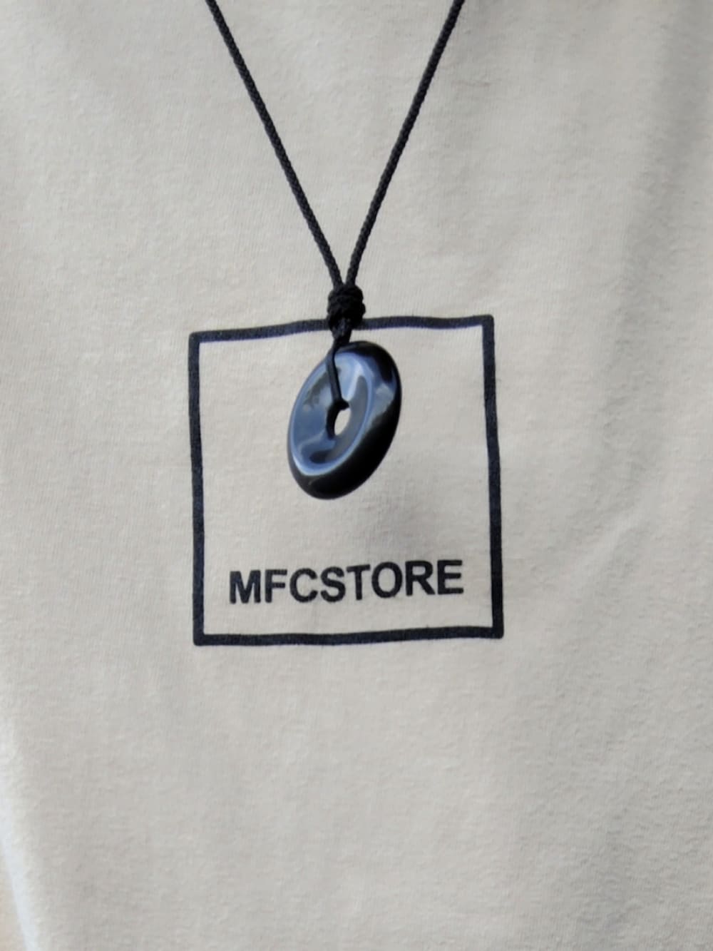 ベージュ系のTシャツ/カットソー、ホワイト系のタンクトップ、ブラック系のデニムパンツを着用したメンズの春コーディネートの3枚目の写真