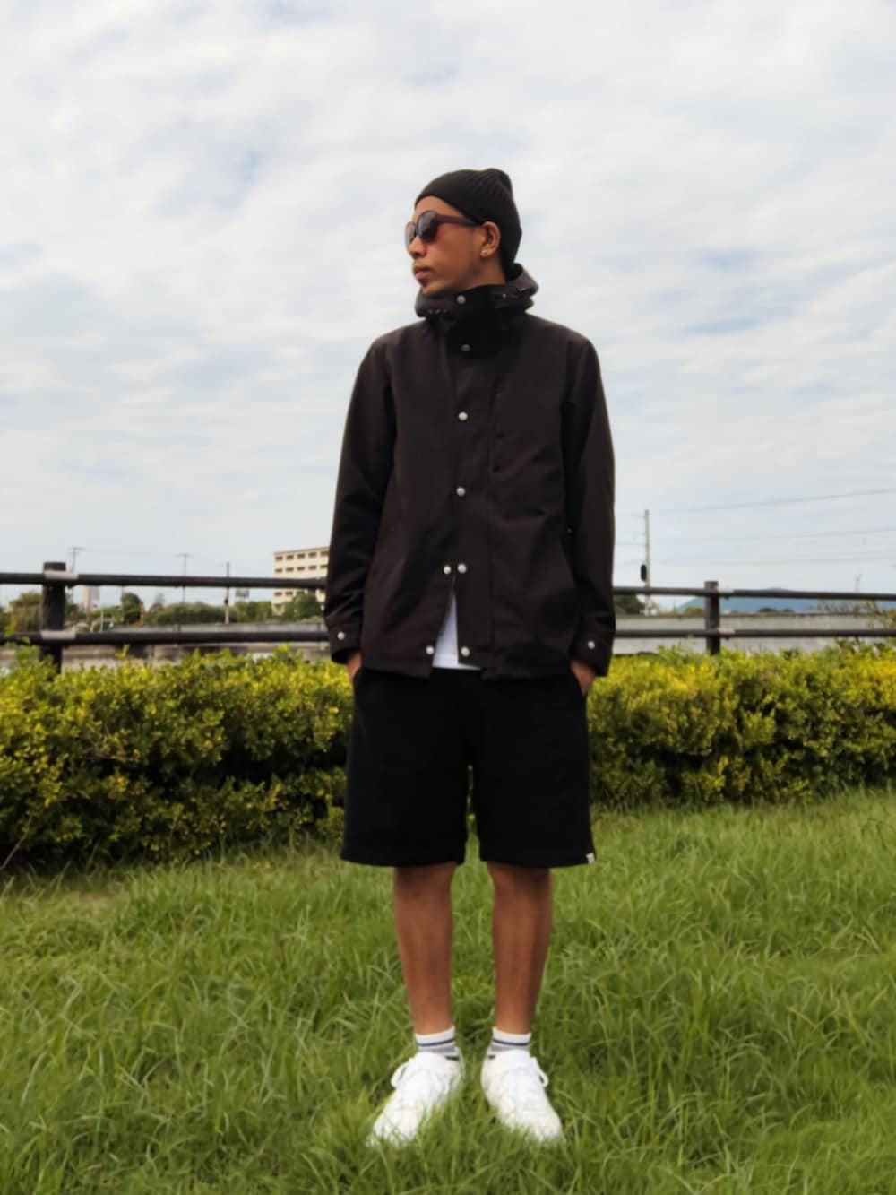 ブラック系のマウンテンパーカー、ブラック系のその他パンツ、ホワイト系のスニーカーを着用したメンズの秋コーディネートの2枚目の写真