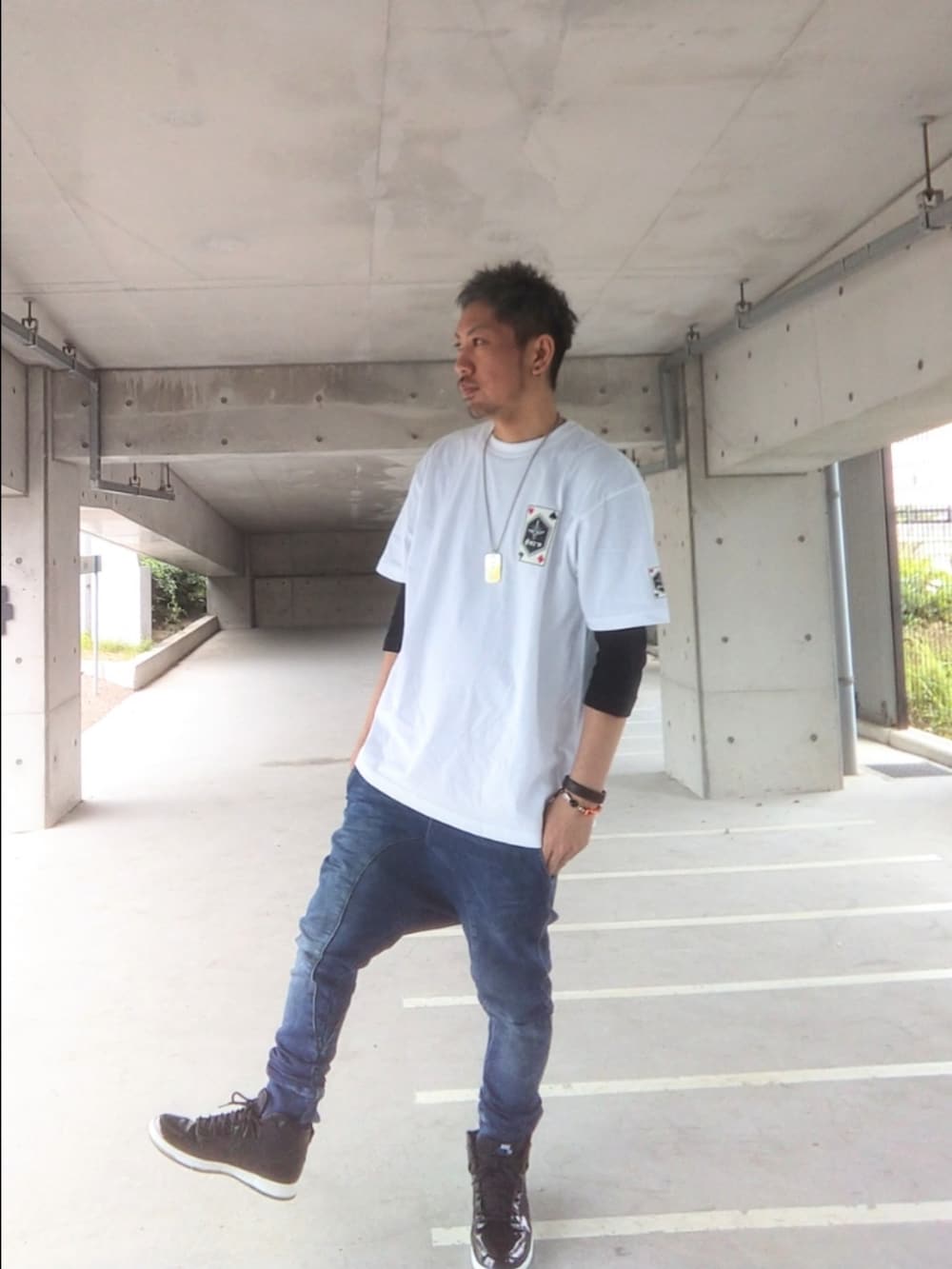 ホワイト系のTシャツ/カットソー、ブラック系のスニーカー、ブルー系のパンツを着用したメンズの春コーディネートの2枚目の写真