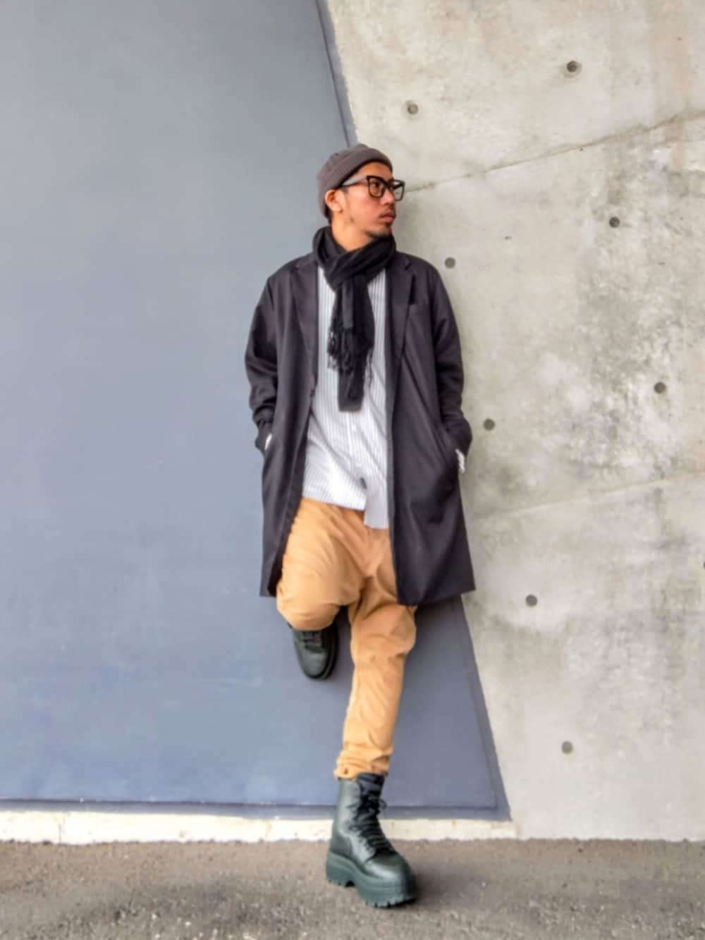 ブラック系のチェスターコート、グレー系のシャツ/ブラウス、ベージュ系のその他パンツを着用したメンズの春コーディネートの2枚目の写真