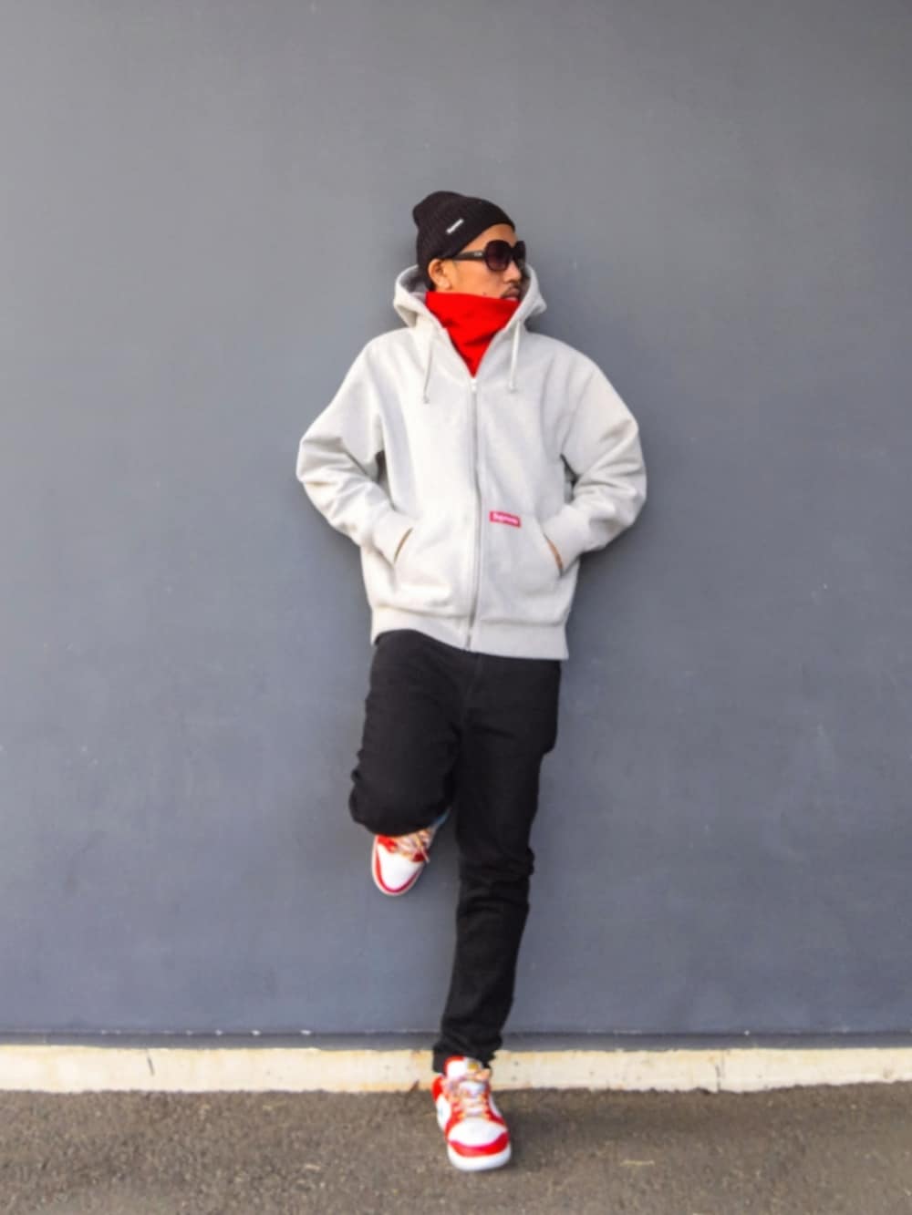 グレー系のパーカー、ブラック系のデニムパンツ、その他のスニーカーを着用したメンズの冬コーディネートの2枚目の写真