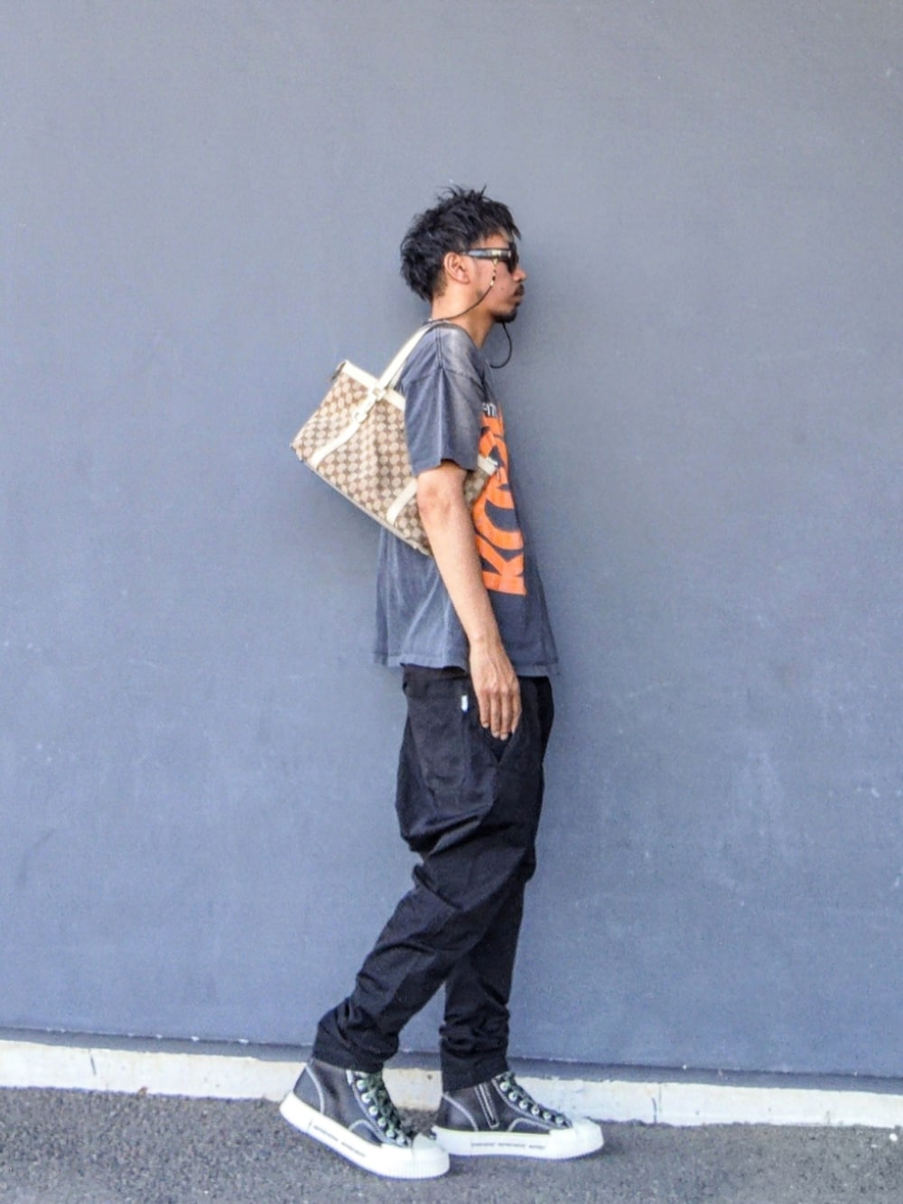 グレー系のTシャツ/カットソー、ベージュ系のトートバッグ、ブラック系のその他パンツを着用したメンズの夏コーディネートの2枚目の写真