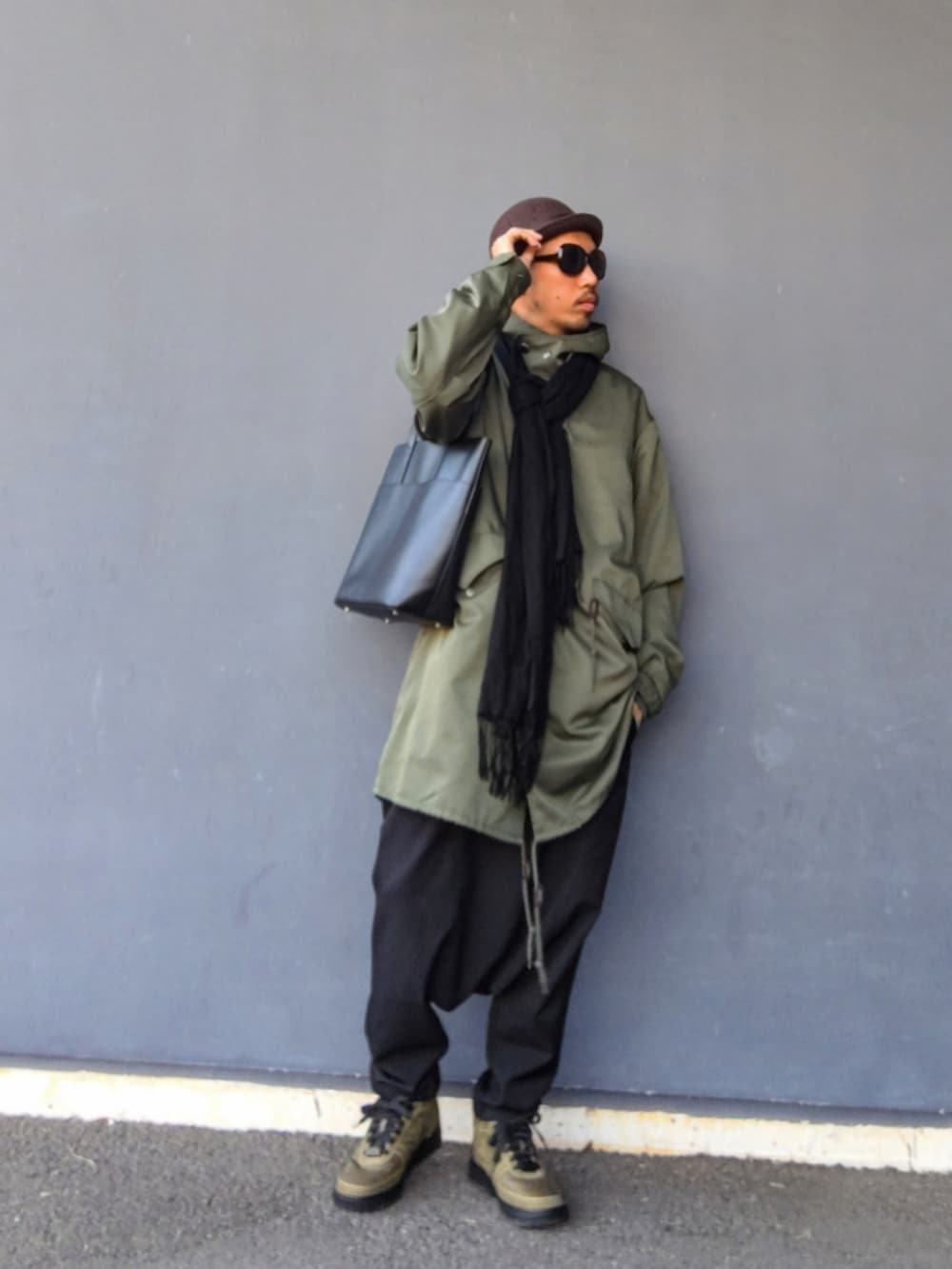 グリーン系のモッズコート、ブラック系のその他パンツ、グリーン系のスニーカーを着用したメンズの冬コーディネートの2枚目の写真