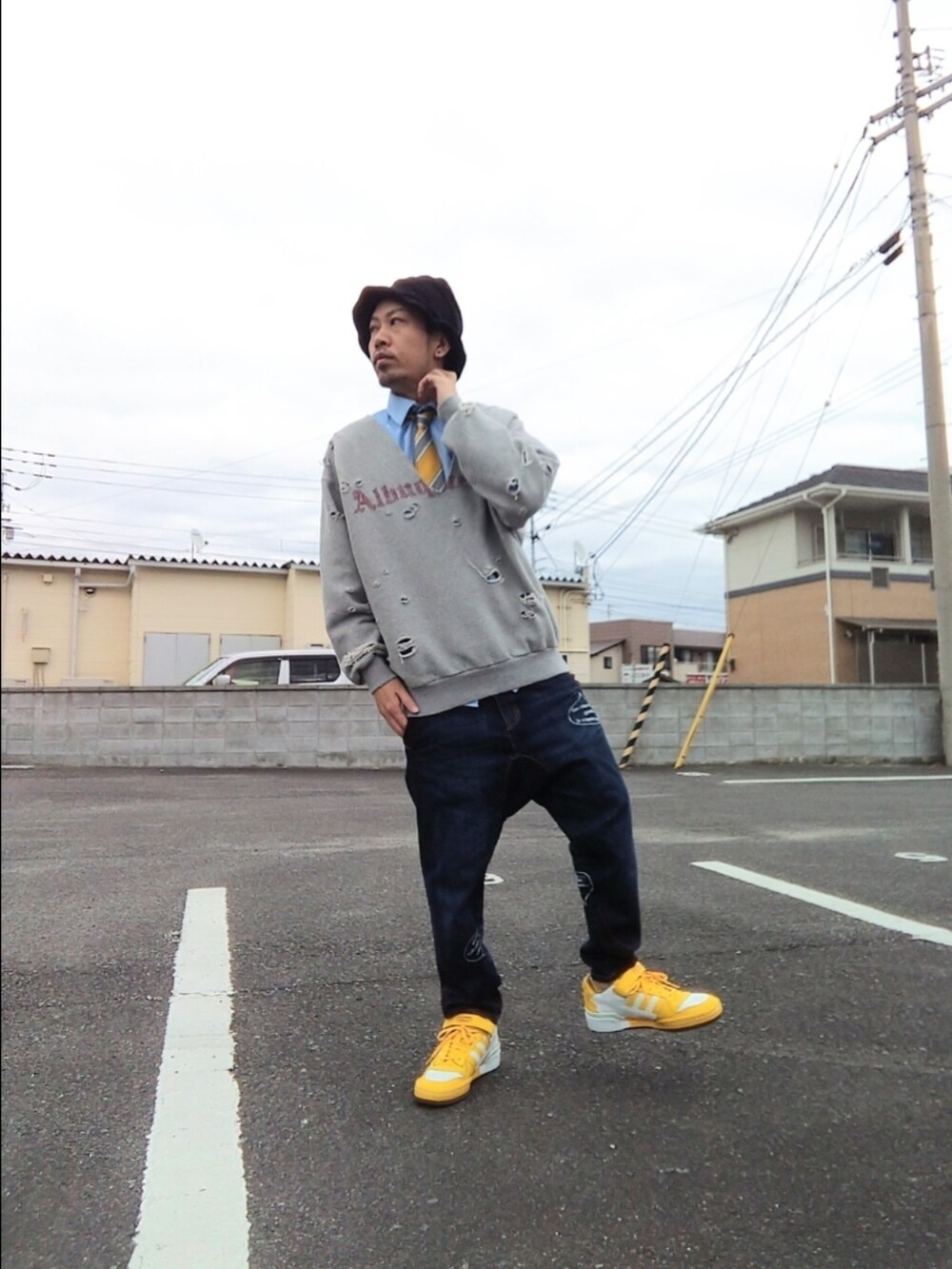 イエロー系のスニーカー、グレー系のスウェット、ブルー系のシャツ/ブラウスを着用したメンズの冬コーディネートの2枚目の写真