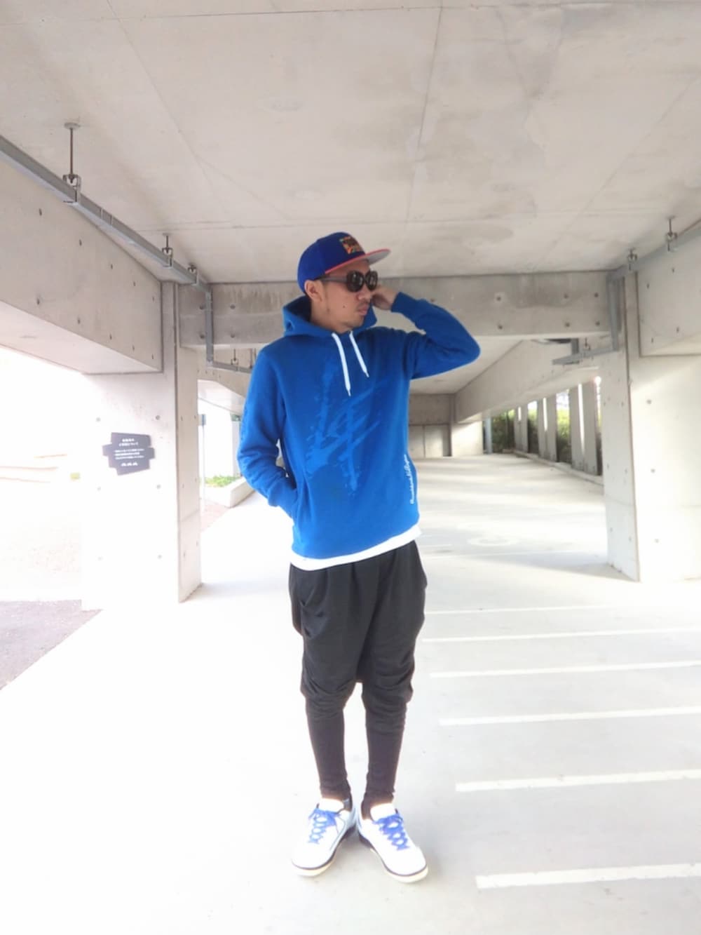 ブルー系のパーカー、ブラック系のその他パンツ、ホワイト系のスニーカーを着用したメンズの冬コーディネートの3枚目の写真