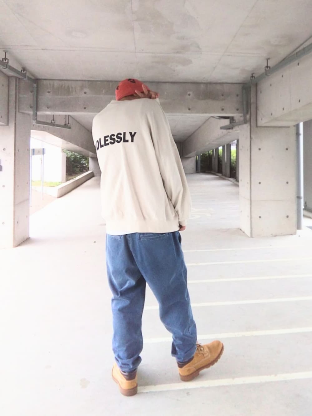 ホワイト系のスウェット、ブルー系のデニムパンツ、イエロー系のブーツを着用したメンズの秋コーディネートの3枚目の写真