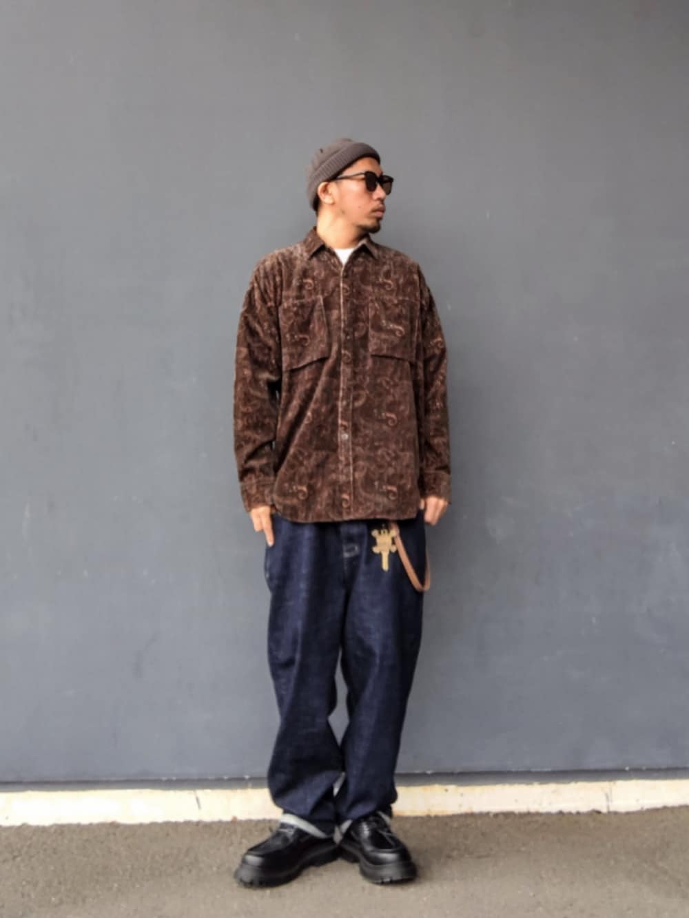 ブラウン系のシャツ/ブラウス、ブルー系のデニムパンツ、ブラック系のモカシン/デッキシューズを着用したメンズの春コーディネートの2枚目の写真