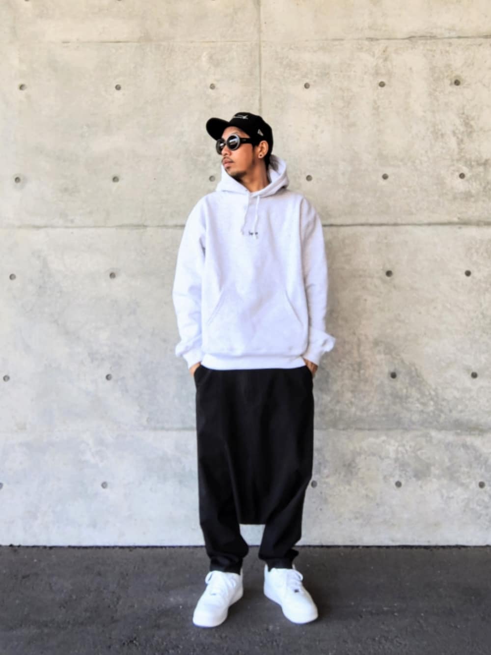 グレー系のパーカー、ブラック系のその他パンツ、ホワイト系のスニーカーを着用したメンズの冬コーディネートの2枚目の写真