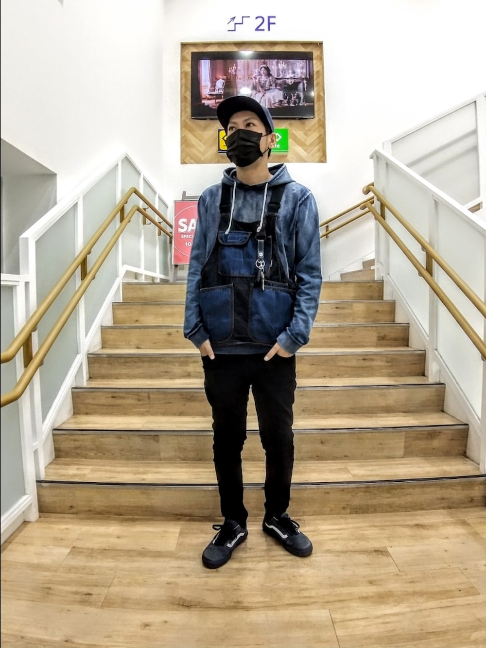 ブルー系のベスト、ブルー系のパーカー、ブラック系のデニムパンツを着用したメンズの秋コーディネートの2枚目の写真