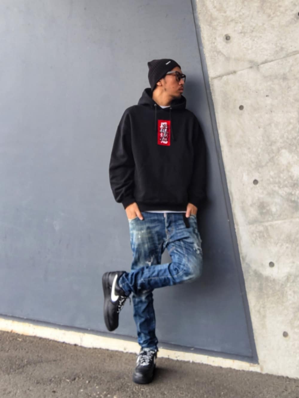 ブラック系のパーカー、ブルー系のデニムパンツ、ブラック系のスニーカーを着用したメンズの冬コーディネートの2枚目の写真
