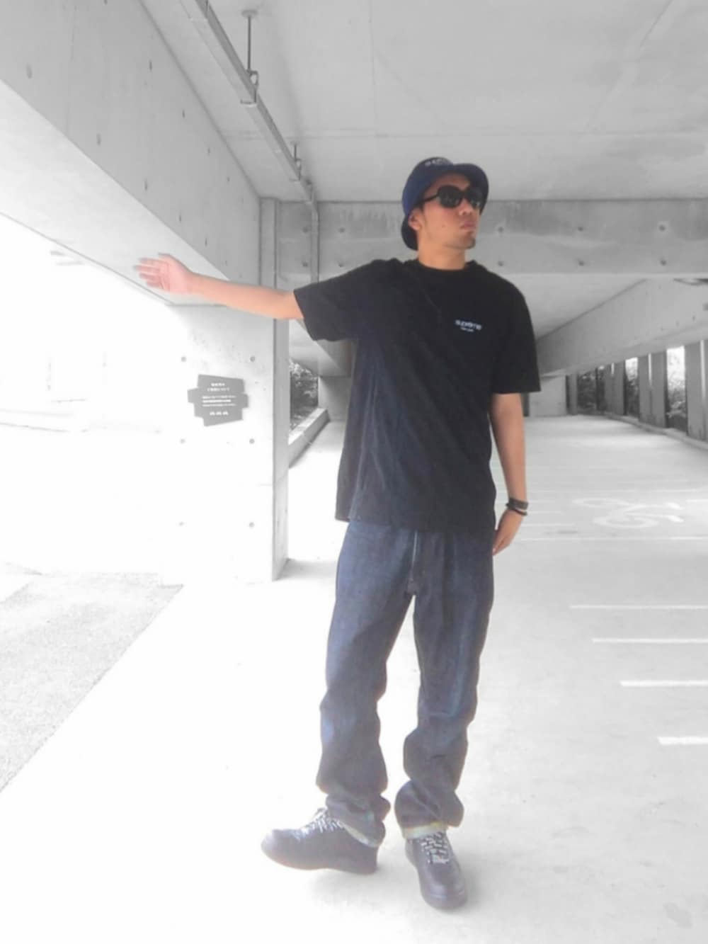 ブラック系のTシャツ/カットソー、ブルー系のデニムパンツ、ブラック系のスニーカーを着用したメンズの夏コーディネートの2枚目の写真