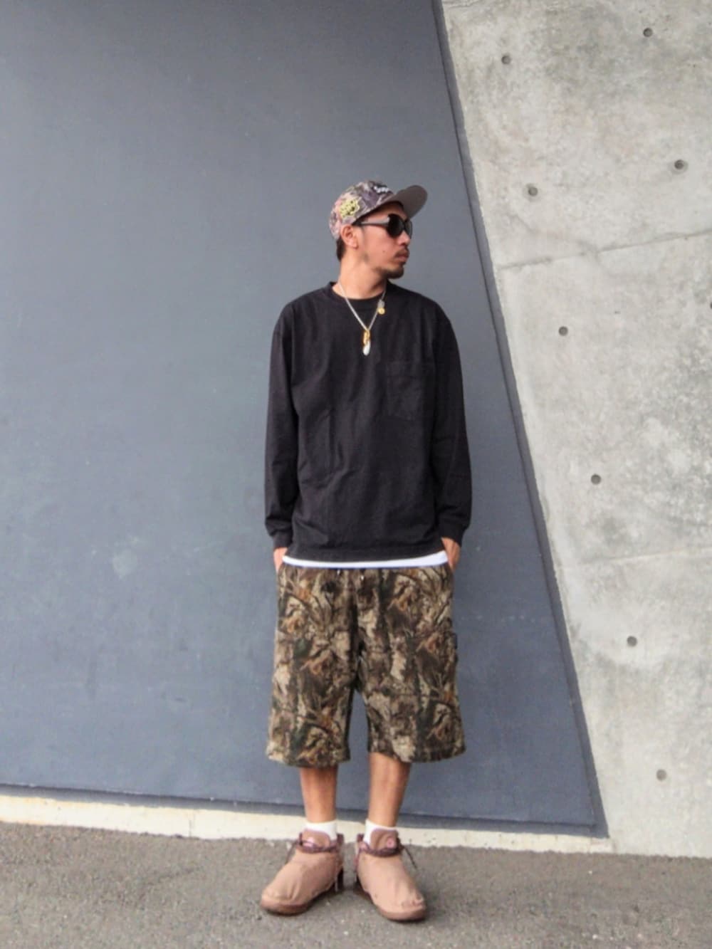 ブラック系のTシャツ/カットソー、ホワイト系のタンクトップ、ブラウン系のその他パンツを着用したメンズの秋コーディネートの2枚目の写真