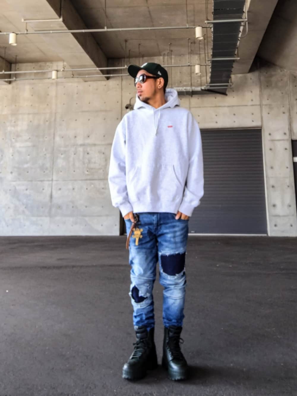 グレー系のパーカー、ブルー系のデニムパンツ、グリーン系のスニーカーを着用したメンズの冬コーディネートの2枚目の写真