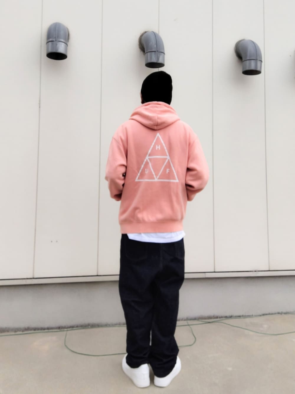 ピンク系のパーカー、ホワイト系のTシャツ/カットソー、ブルー系のデニムパンツを着用したメンズの秋コーディネートの2枚目の写真