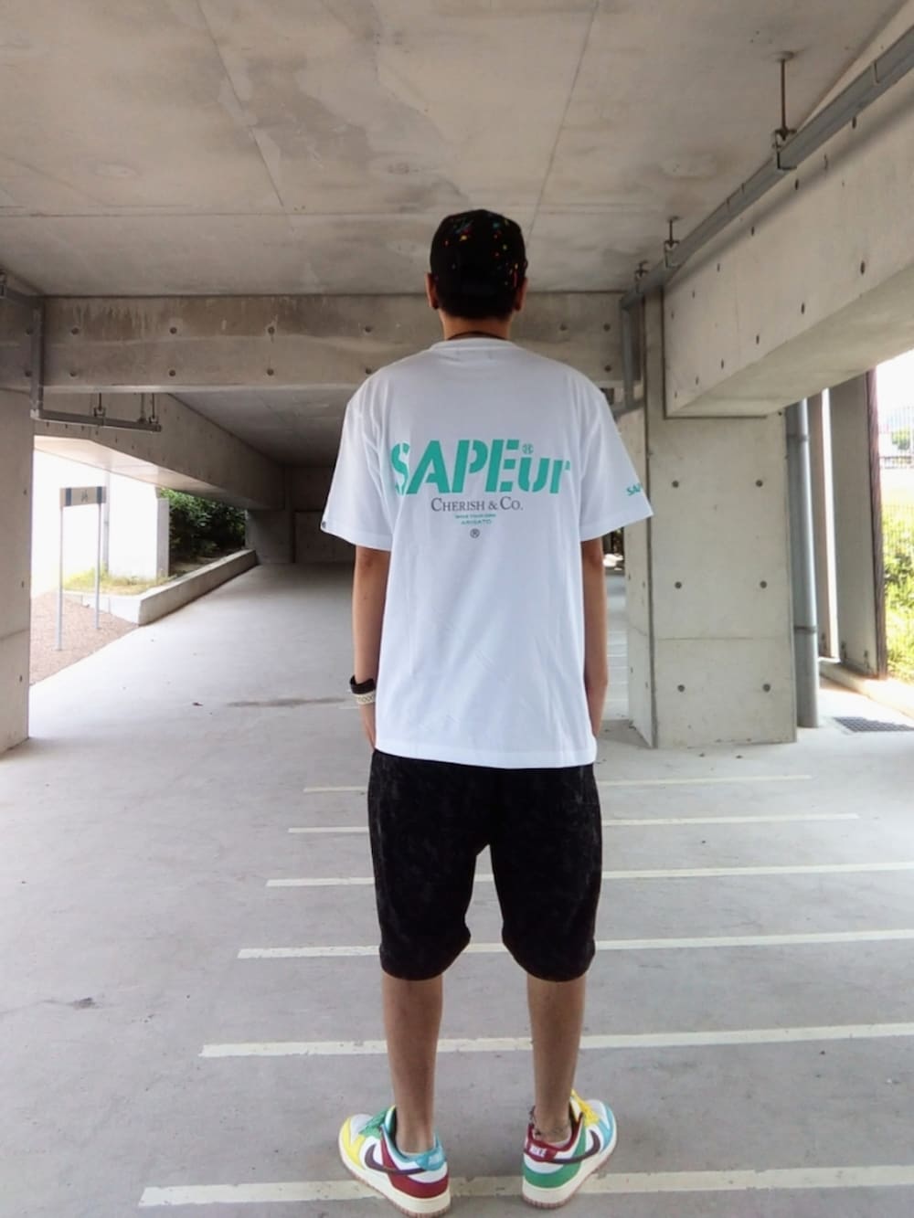 ホワイト系のTシャツ/カットソー、ブラック系のパンツ、その他のスニーカーを着用したメンズの夏コーディネートの3枚目の写真