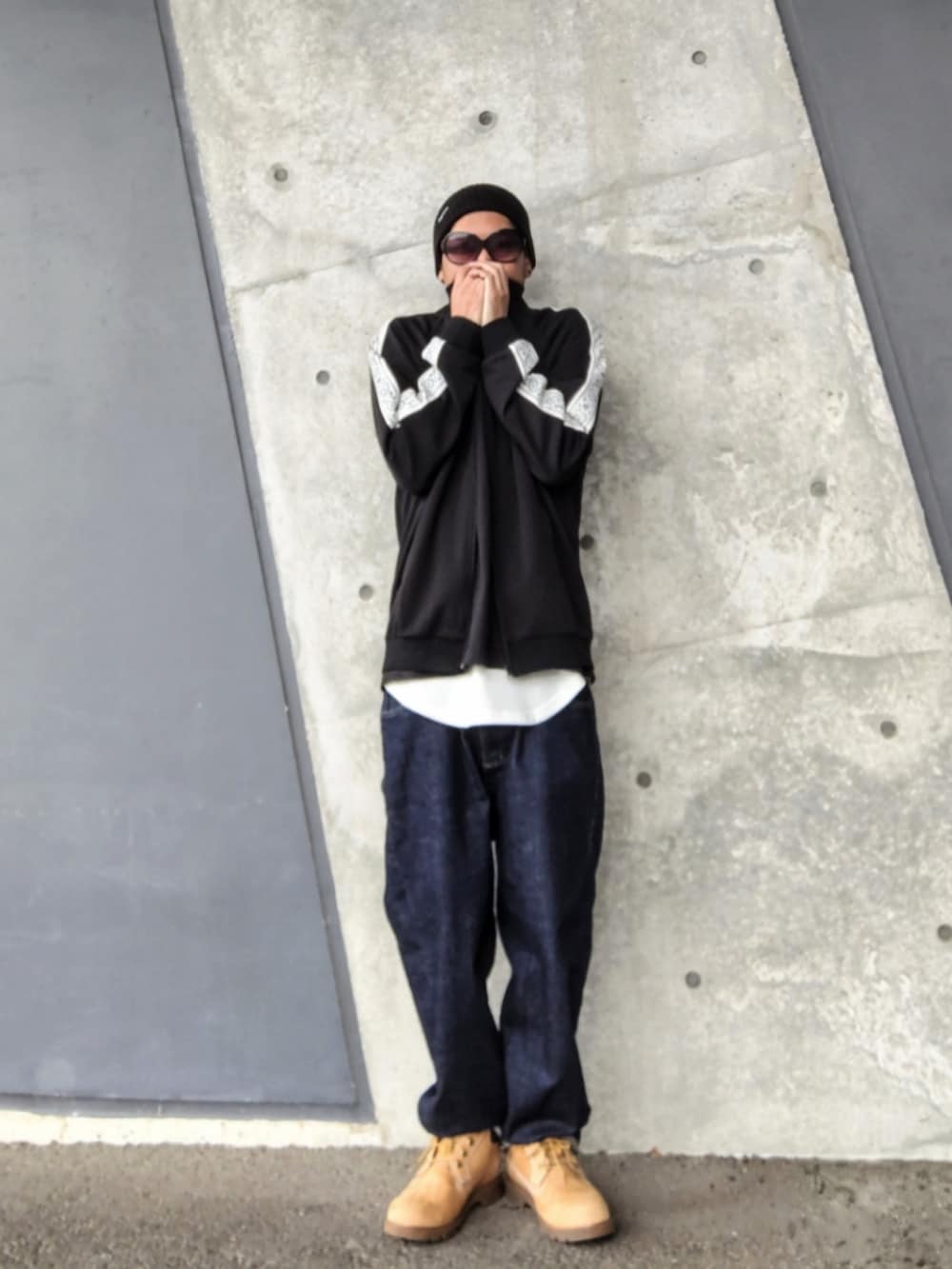 ブラック系のジャージ、ホワイト系のタンクトップ、ブルー系のデニムパンツを着用したメンズの春コーディネートの2枚目の写真