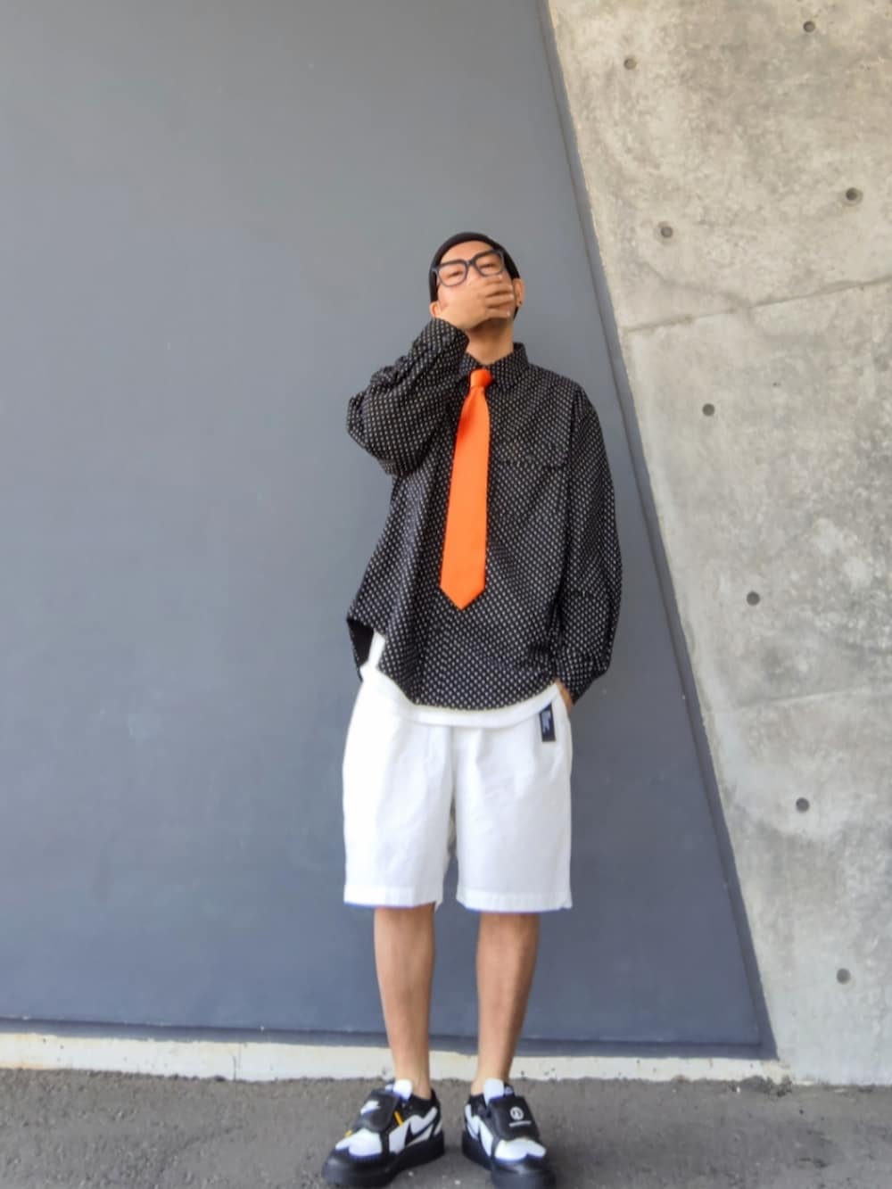 オレンジ系のネクタイ、ブラック系のシャツ/ブラウス、ホワイト系のその他パンツを着用したメンズの春コーディネートの2枚目の写真