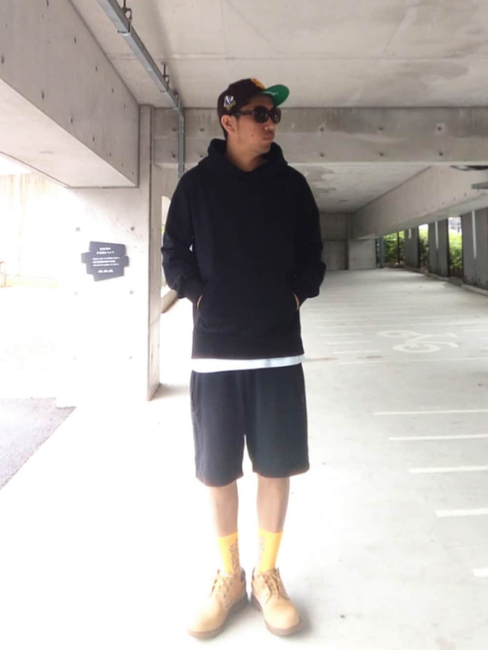 ブラック系のパーカー、ブラック系のその他パンツ、イエロー系のブーツを着用したメンズの春コーディネートの3枚目の写真