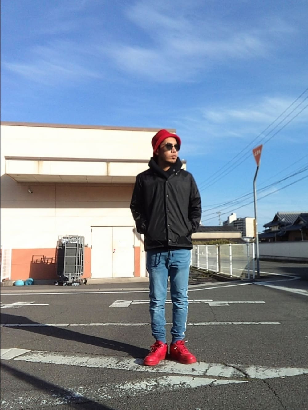 レッド系のスニーカー、ブルー系のパンツ、ブルー系のナイロンジャケットを着用したメンズの冬コーディネートの2枚目の写真