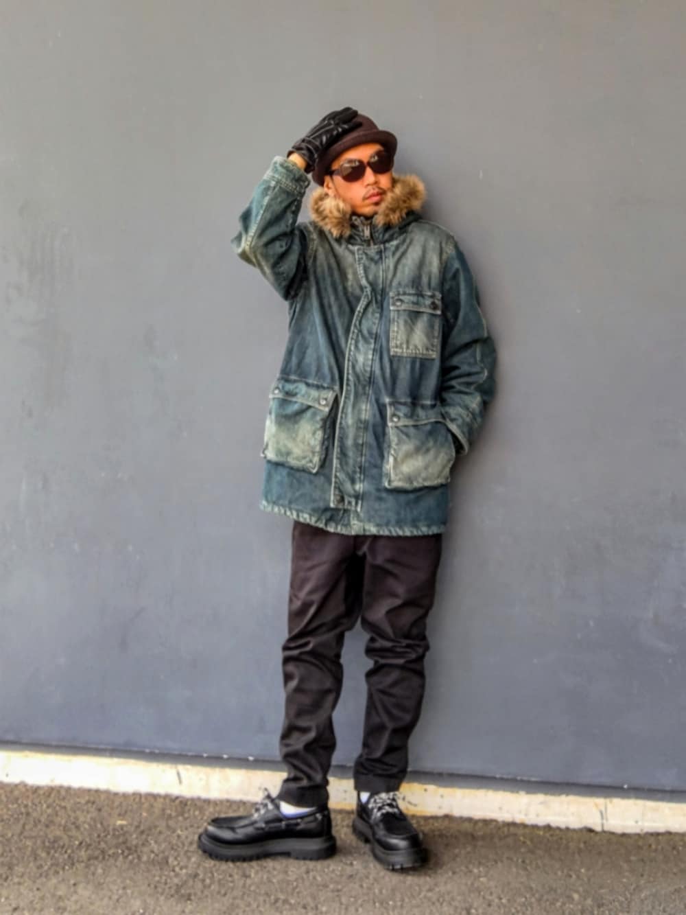 ブルー系のミリタリージャケット、ブラック系のパンツ、ブラック系のモカシン/デッキシューズを着用したメンズの冬コーディネートの2枚目の写真