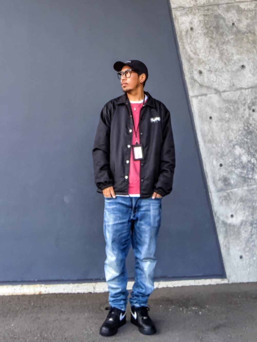 ブラック系のナイロンジャケット、ピンク系のスウェット、ブルー系のデニムパンツを着用したメンズの冬コーディネートの2枚目の写真