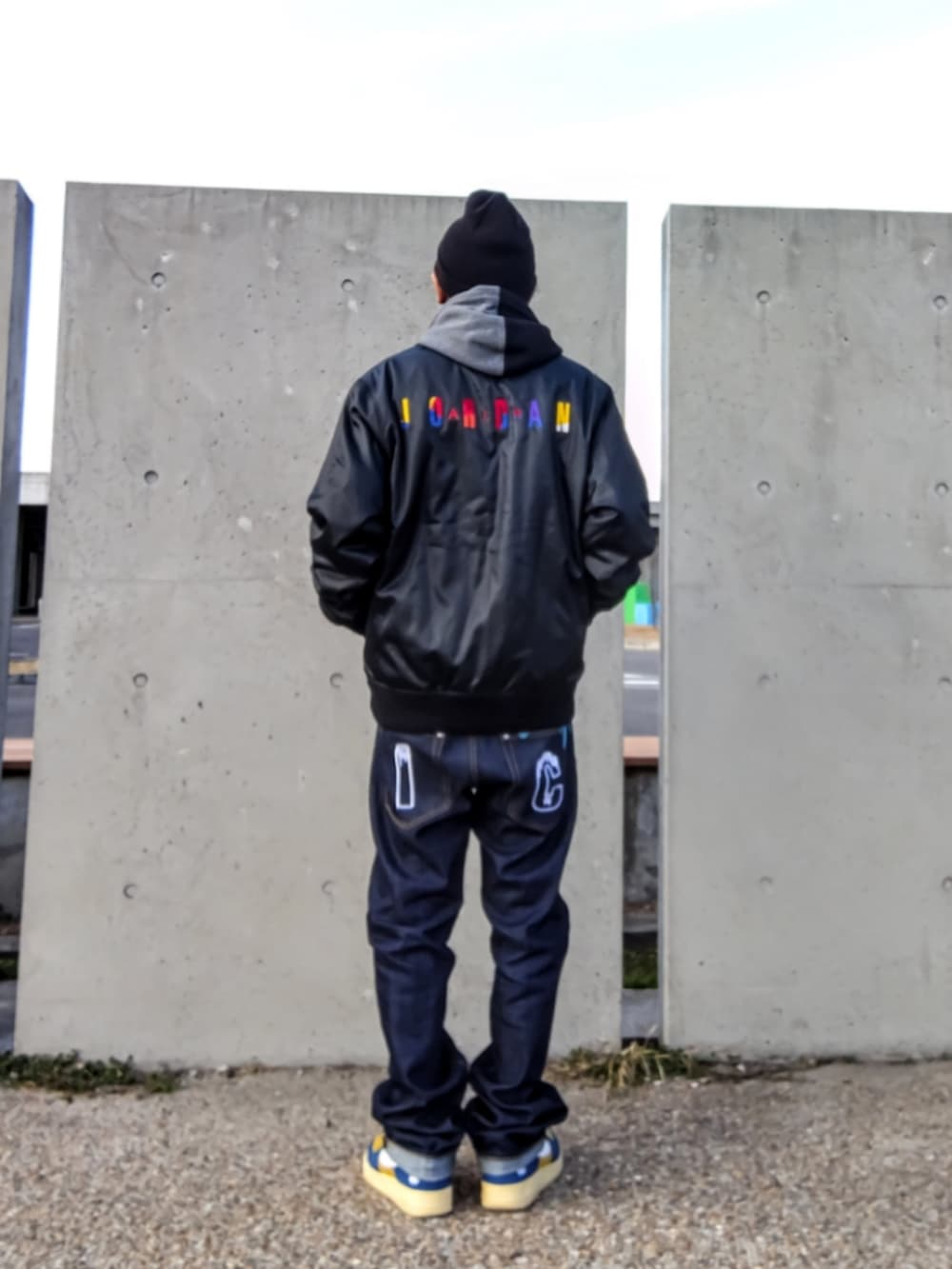 ブラック系のジャケット/アウター、ブラック系のパーカー、ブルー系のデニムパンツを着用したメンズの冬コーディネートの3枚目の写真