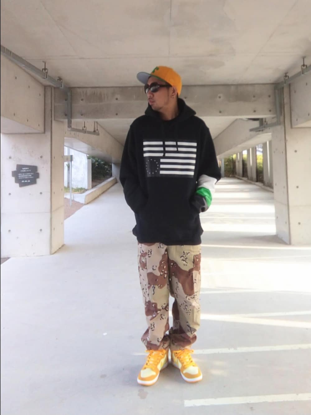 ブラック系のパーカー、その他のカーゴパンツ、イエロー系のスニーカーを着用したメンズの冬コーディネートの2枚目の写真