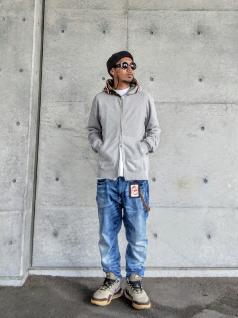 グレー系のパーカー、ホワイト系のTシャツ/カットソー、ブルー系のデニムパンツを着用したメンズの春コーディネートの2枚目の写真