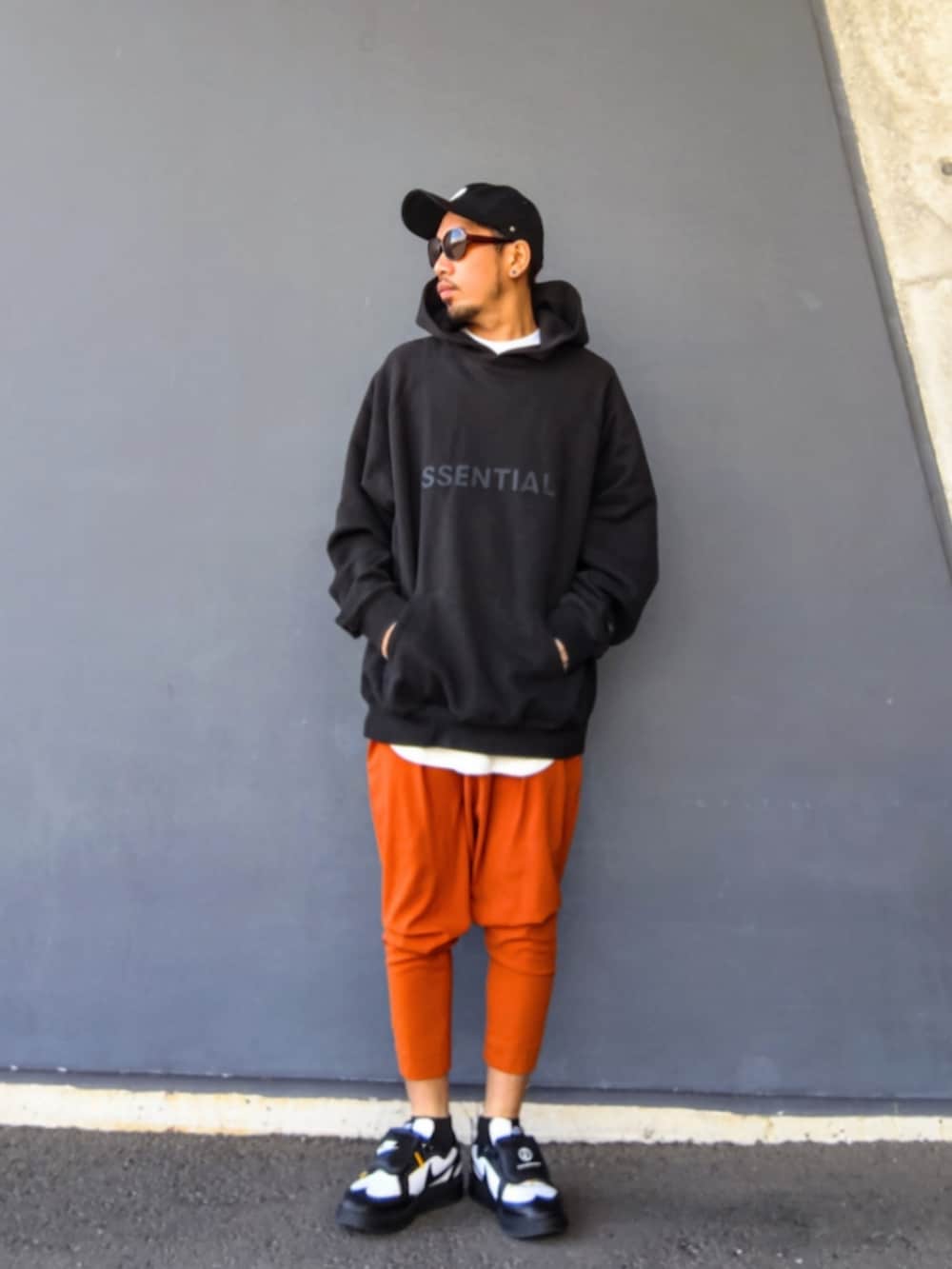 ブラック系のパーカー、ホワイト系のタンクトップ、オレンジ系のその他パンツを着用したメンズの冬コーディネートの3枚目の写真