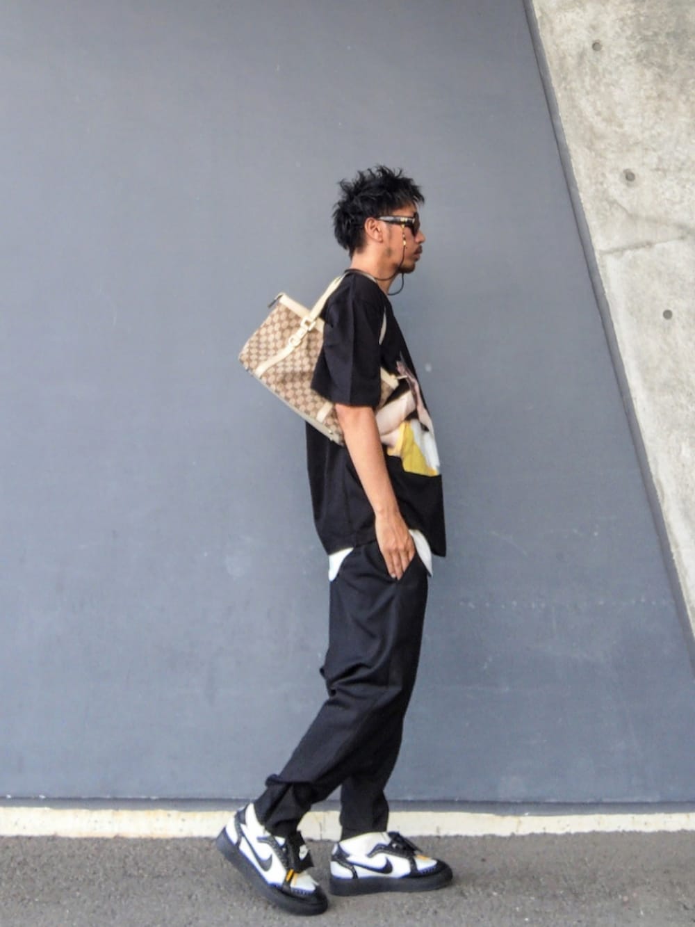ブラック系のTシャツ/カットソー、ホワイト系のタンクトップ、ベージュ系のトートバッグを着用したメンズの夏コーディネートの3枚目の写真