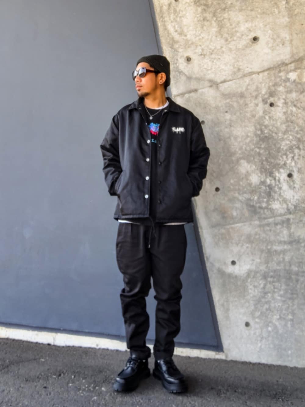 ブラック系のナイロンジャケット、ブラック系のスウェット、ブラック系のモカシン/デッキシューズを着用したメンズの冬コーディネートの2枚目の写真