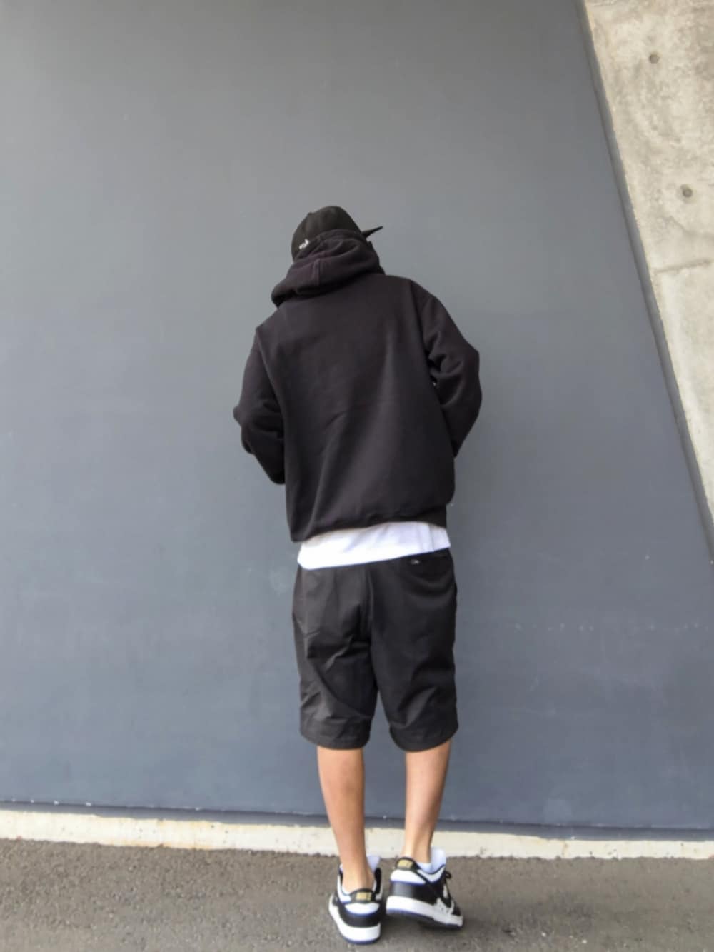 ブラック系のパーカー、ブラック系のその他パンツ、その他のスニーカーを着用したメンズの春コーディネートの2枚目の写真