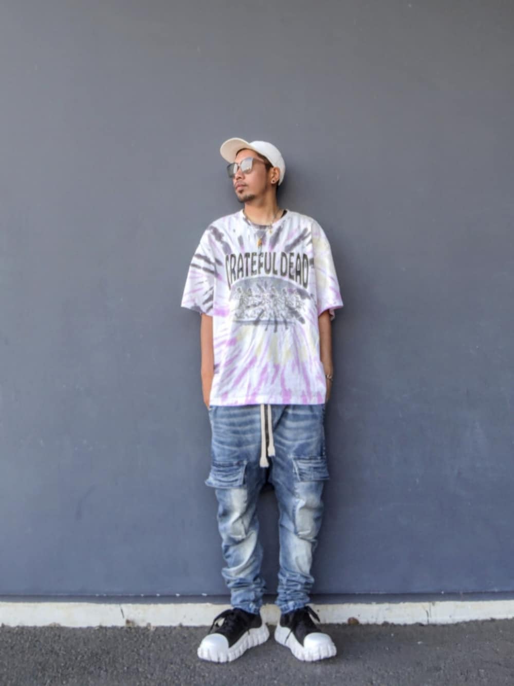ピンク系のTシャツ/カットソー、ブラック系のタンクトップ、ブルー系のデニムパンツを着用したメンズの夏コーディネートの2枚目の写真