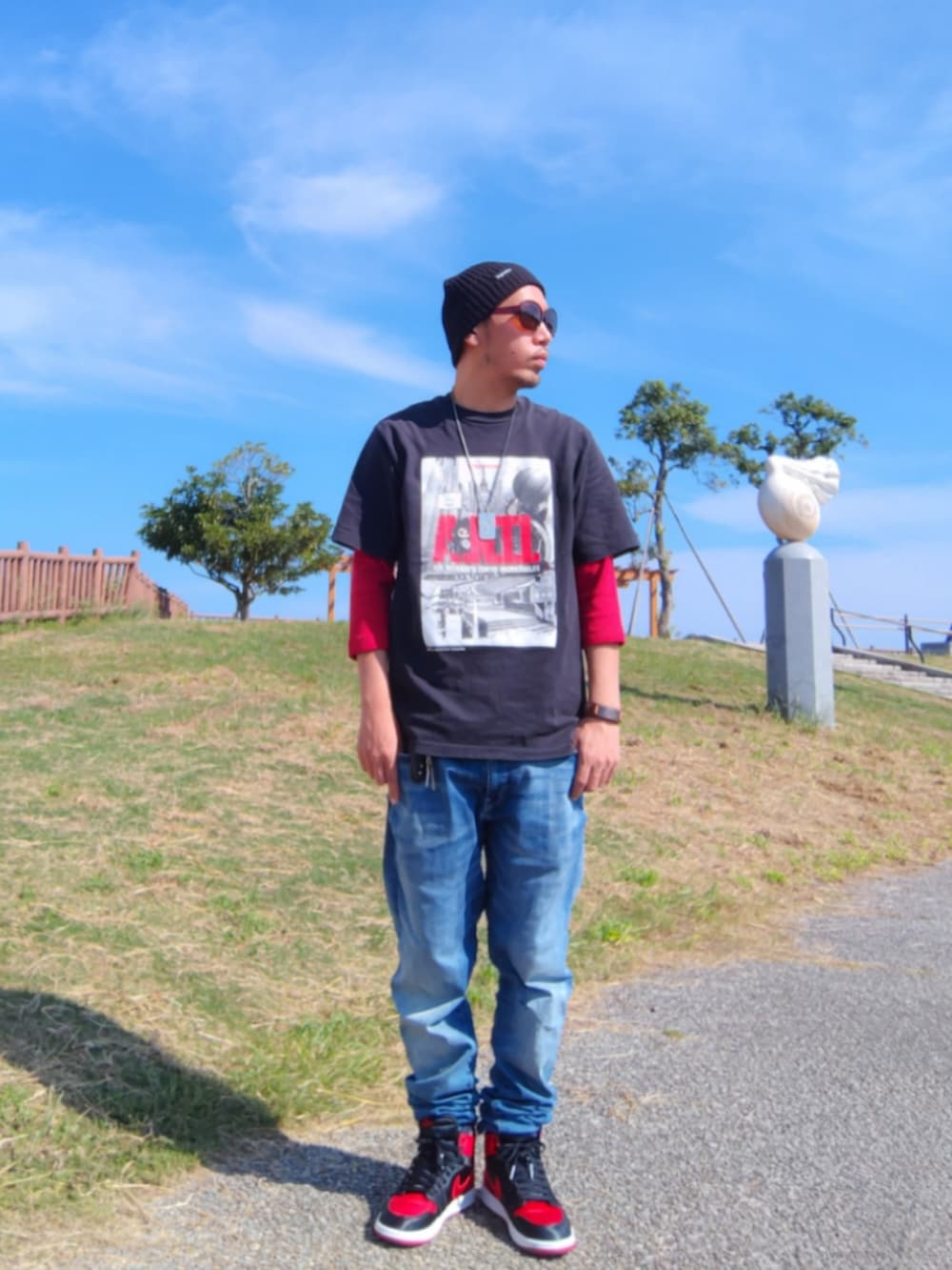 ブラック系のTシャツ/カットソー、ブルー系のデニムパンツ、ブラック系のスニーカーを着用したメンズの秋コーディネートの2枚目の写真