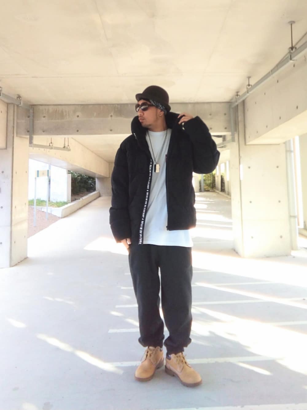 ブラック系のダウンジャケット/コート、ブラック系のスウェットパンツ、イエロー系のブーツを着用したメンズの冬コーディネートの3枚目の写真