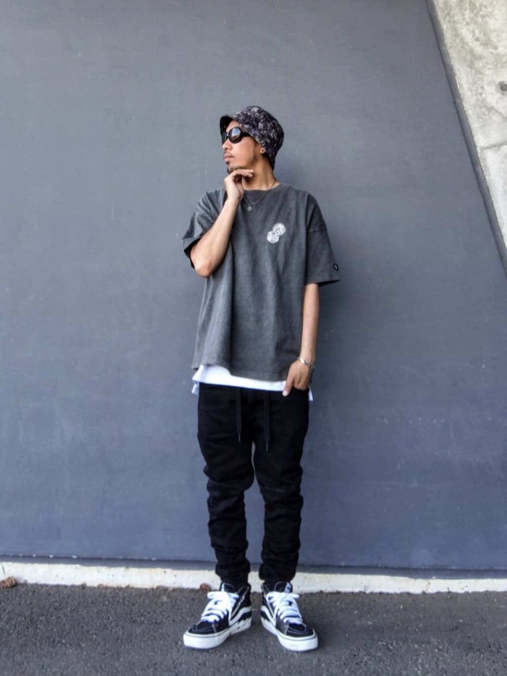 ブラック系のTシャツ/カットソー、ホワイト系のタンクトップ、ブラック系のデニムパンツを着用したメンズの春コーディネートの2枚目の写真