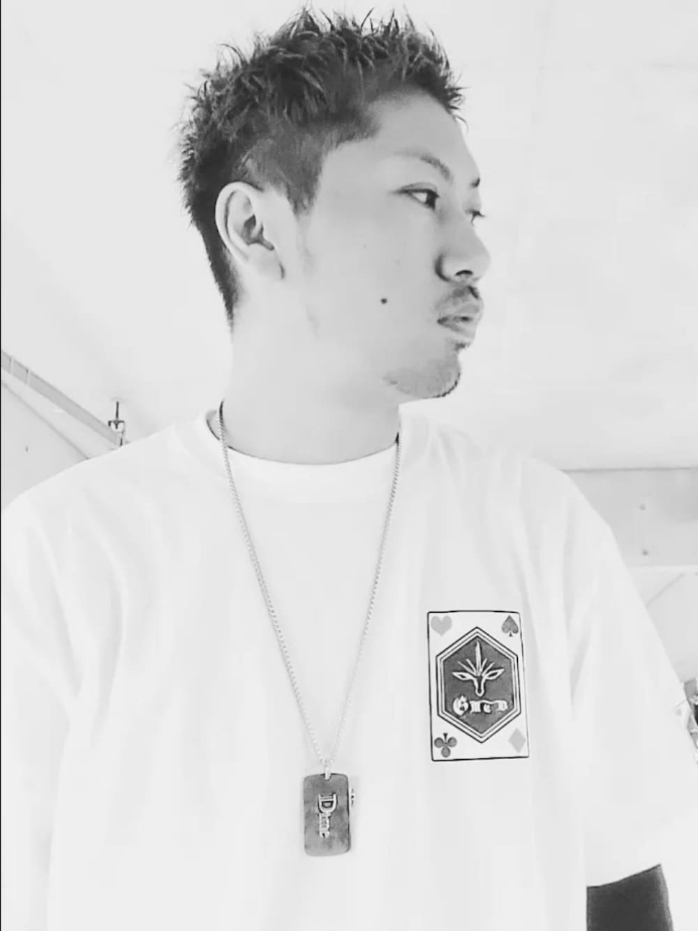 ホワイト系のTシャツ/カットソー、ブラック系のスニーカー、ブルー系のパンツを着用したメンズの春コーディネートの3枚目の写真