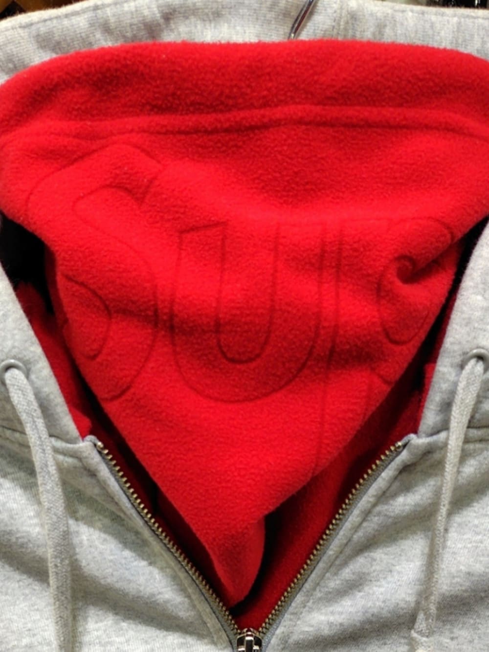 グレー系のパーカー、ブルー系のデニムパンツ、レッド系のスニーカーを着用したメンズの冬コーディネートの5枚目の写真