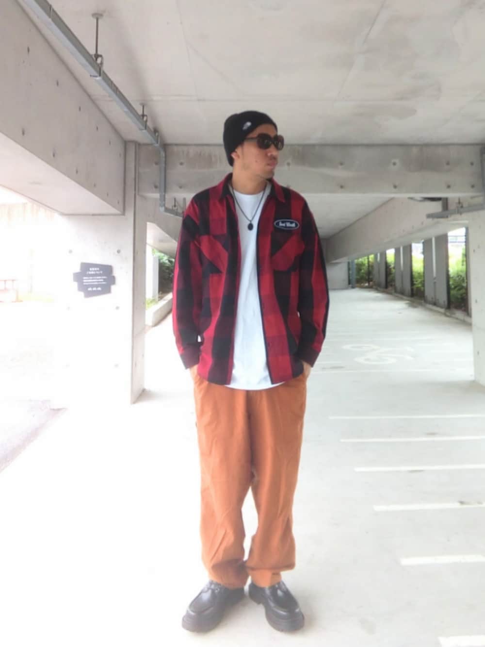 ブラック系のTシャツ/カットソー、ベージュ系のチノパンツ、イエロー系のブーツを着用したメンズの春コーディネートの3枚目の写真