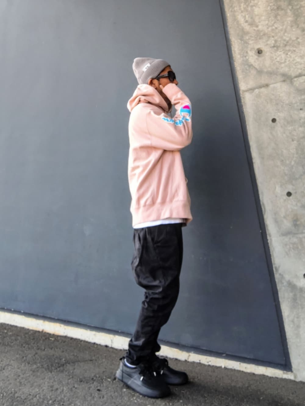 ピンク系のパーカー、ホワイト系のTシャツ/カットソー、ブラック系のパンツを着用したメンズの冬コーディネートの2枚目の写真