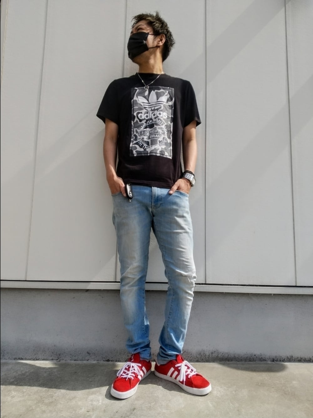 ブラック系のTシャツ/カットソー、ブルー系のデニムパンツ、レッド系のスニーカーを着用したメンズの夏コーディネートの2枚目の写真