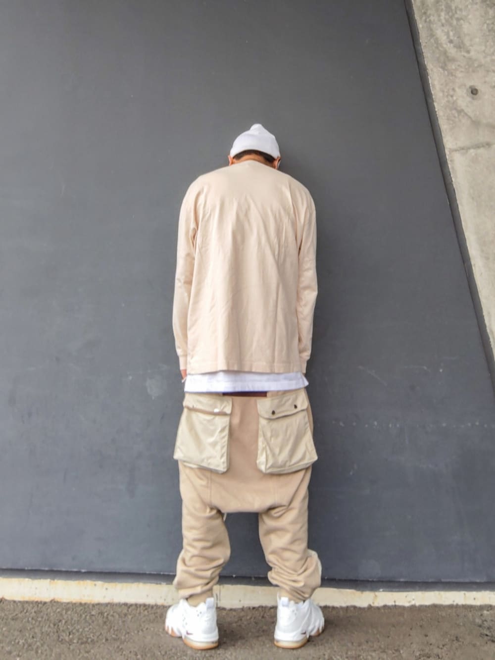 ベージュ系のTシャツ/カットソー、ホワイト系のタンクトップ、ベージュ系のその他パンツを着用したメンズの秋コーディネートの2枚目の写真